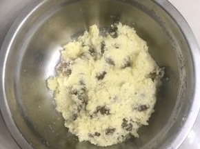 3 这时来做椰蓉馅，把室温软化的黄油加入白砂糖和一个全蛋液，用手动打蛋器搅打均匀至白砂糖溶化，加入椰蓉、葡萄干拌搅均匀，放入冰箱冷藏备用。