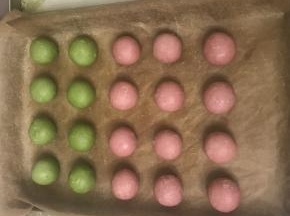 8 取一個酥皮條用手指從中間壓一下，二頭朝上用手掌壓扁，用擀麵杖向四面擀開，包上椰蓉餡，收口朝下用二手掌搓圓，放入烤盤（我還做了4 個雙色的開口酥，把油皮和油酥再各分為二，同上的方法擀開二種色的油酥皮，紅曲粉皮上面放上抺茶皮包上餡就好）