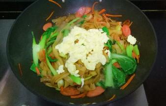 加入青菜，倒入老抽，味极鲜，用筷子翻炒片刻，加入鸡蛋翻炒