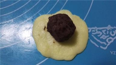 取一白色面团，放上豆沙馅
