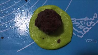 取一绿色面团，放入馅料