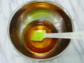 将转换糖浆、枧水、花生油倒入碗中，用手动打蛋器搅拌均匀