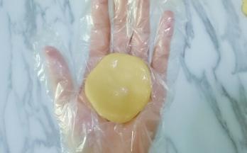 取一块皮放在手心按扁，（我带的一次性手套嫌带手套不好操作的在手上拍点熟面粉防粘）