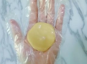 取一块皮放在手心按扁，（我带的一次性手套嫌带手套不好操作的在手上拍点熟面粉防粘）