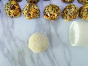 做好的月饼胚在熟粉中滚一圈