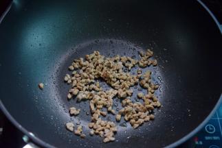 再热油，把肉粒炒熟炒干