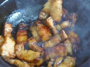 砂锅里倒入油，放入冰糖，等糖融化后变色放入五花肉翻炒上色。