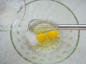 盆中打入两个鸡蛋，加入白砂糖。