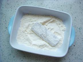 把带鱼段放入干面粉中，两面均匀的沾上一层薄薄的面粉。