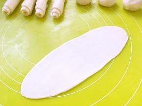 将松弛好的面团擀成长条，卷成牛舌卷状，盖保鲜膜松弛15分钟