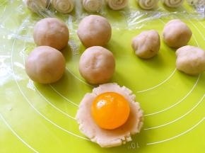 用莲蓉馅包裹上咸蛋黄，收好收口