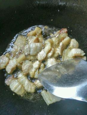 锅里烧水，把整块五花肉入锅煮一下 ，再捞起切片，然后放入炒锅中煸炒