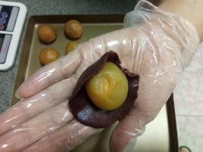 拿一个面团在掌心中按扁成片状，包入一个馅料，还是前面的方法，慢慢收口。