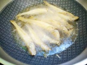 锅里适量植物油烧七成热，将鱼一个一个放入锅，要隔间隙，用筷子不停翻动防止黏连，以文火炸至表面金黄即可。