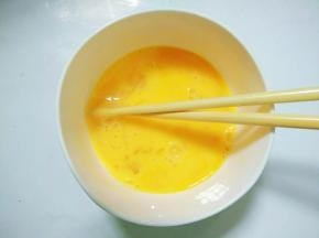 鸡蛋磕入碗里搅匀备用。