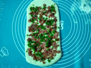 面片上均匀撒上一层薄薄的盐，铺上肉馅，再撒上葱花，收口的一边留点空白。