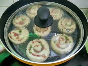 整成圆形，用手轻轻压扁放入抹油的盘子里，盖上保鲜膜静置15分钟。
