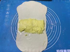 松弛好的面团擀成长方型，将片状黄油放到面团中间部位。