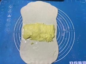 松弛好的面团擀成长方型，将片状黄油放到面团中间部位。