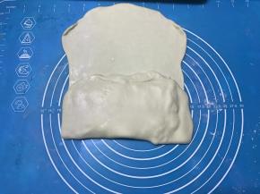 将左右两侧的面团向中间折起，捏紧封口。