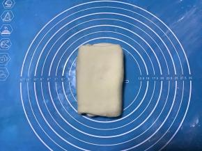 再次对折，盖保鲜膜松弛20分钟，如果家里温度高，可放冰箱冷藏松弛。