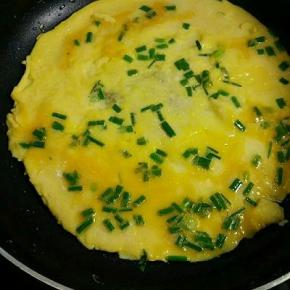 锅里油烧七成热，倒入葱花鸡蛋液，以小火慢慢煎，煎至一面凝固后，再翻面煎熟即可。