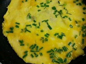 锅里油烧七成热，倒入葱花鸡蛋液，以小火慢慢煎，煎至一面凝固后，再翻面煎熟即可。