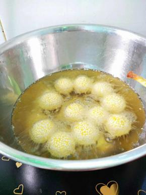 锅里倒入适量植物油烧七成热，转小火，逐一放入麻团，用筷子不停搅动，让其碰撞，微火炸至金黄色即可。
