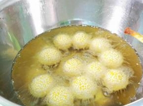 锅里倒入适量植物油烧七成热，转小火，逐一放入麻团，用筷子不停搅动，让其碰撞，微火炸至金黄色即可。