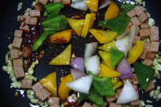 直至茄酱炒至粘稠后，加彩椒丁、洋葱丁并加入适量的糖、盐