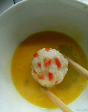 鸡蛋打成蛋液，把饭团放入蛋液里面转一圈