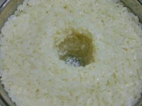 放入酸奶机中，把米饭压实，中间戳一个洞