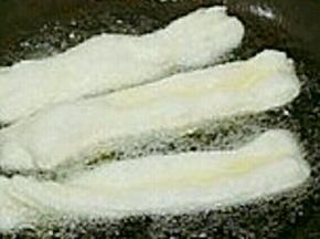 然后锅里放油到七八成热，双手拿起油条反方向扭一下，快速放入油锅中炸，快速出锅