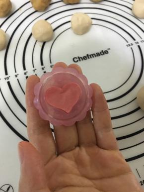 取一些桃山皮，加少量红曲粉，将颜色揉均匀后放在模具的花片里，压几下并去除多余的