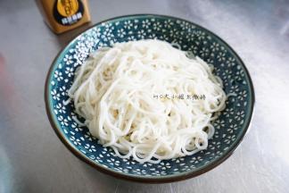 煮米粉，煮熟没有硬芯就可以了，一般干米粉要煮很久，你就可以去准备其他食材了，煮熟了以后过冷水沥干就可以了。黄瓜切丝，泡菜切丝，切葱花，捣蒜末，煮鸡蛋。