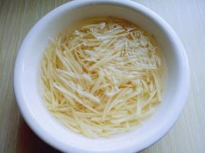 土豆去皮，用插板插土豆丝。之后放在大口器具中，用冷水冲洗两遍，再换清水泡5分钟，捞出淋干水份。