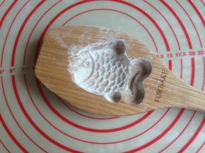 木质鱼模具洒上玉米淀粉，将多余的粉敲出来