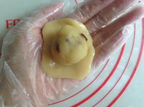 饼皮压扁，放上馅料，将饼皮慢慢向上推，收口