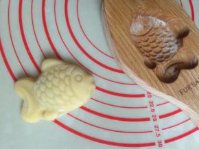 将模具倒扣，在桌面上敲一下，整个月饼坯敲出