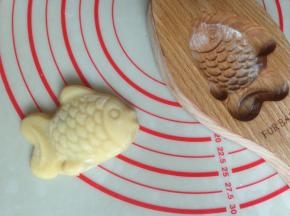 将模具倒扣，在桌面上敲一下，整个月饼坯敲出