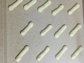 在烤盘上挤成牙签长短的面糊。放入预热好140度的烤箱，上下火中层20分钟