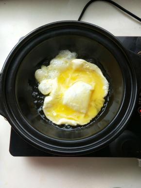 电陶炉启动煎烤键砂锅放入油，油温升起倒入打散的鸡蛋