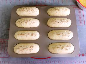 烤箱底部放碗热水，模具放入烤箱发酵30分钟左右。发酵1.5倍大取出刷一层薄薄的蛋液，撒上适量的白芝麻。同时预热烤箱170度。