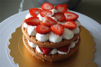 将切片的草莓放在淡奶油上，然后盖上第二层蛋糕体，如此类推。