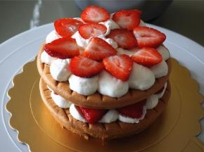 将切片的草莓放在淡奶油上，然后盖上第二层蛋糕体，如此类推。