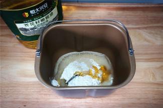 先制作水油皮：将富强粉，橄榄油，麦芽糖，酵母，水放入面包机桶内，然后启动揉面程序。