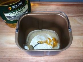 先制作水油皮：将富强粉，橄榄油，麦芽糖，酵母，水放入面包机桶内，然后启动揉面程序。