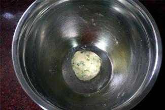 接着制作香葱油酥皮：将玉米淀粉，隔水融化了的黄油，盐，香葱碎混合揉成团。