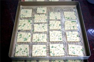 将饼干坯移入烤盘，表面喷洒少许清水后放入烤箱，用发酵程序发酵至1.5~2倍厚，取出。然后180度上下火预热烤箱后放入中层，烘烤13分钟左右至表面微微金黄即可取出。