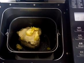 第一次揉面结束后，加入软化的黄油块，然后启动第二次揉面程序，时间15分钟。